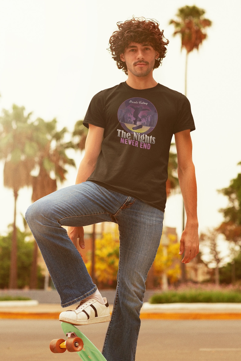 May include: A black t-shirt with a purple and blue graphic of a person skateboarding. The graphic is in a circle with the text "Arcade Feeling" at the top and "The Nights Never End" at the bottom.