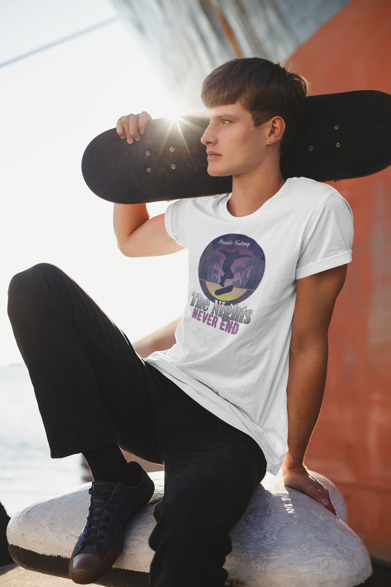 May include: White t-shirt with a graphic of a person skateboarding in front of a sunset with the text "Route Feeling" and "The Nights Never End".
