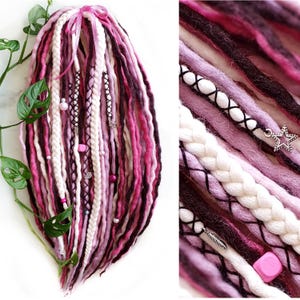 May include: Pink, white and dark purple synthetic dreadlocks with silver and pink beads and charms.