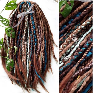 Puede incluir: Dreadlocks sintéticas marrones, azules y blancas con cuentas y abalorios decorativos.
