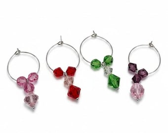 May include: Four wine glass charms with silver hoops and colorful faceted beads. The charms feature pink, red, green, and purple beads, adding a decorative touch to stemware. These charms are ideal for parties and gatherings.