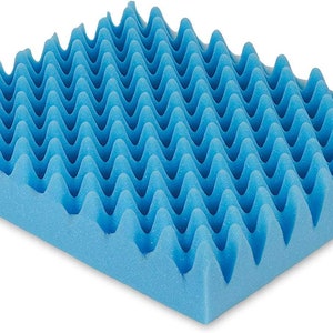 May include: A blue foam cushion with a wave-like pattern. The cushion is designed to provide comfort and support.