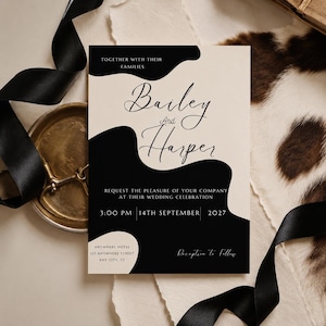 Puede incluir: Una invitaci&oacute;n de boda con fondo crema y formas abstractas negras. El texto dice "Bailey and Harper" con la fecha y hora de la boda. Cinta negra y un plato dorado en el fondo.