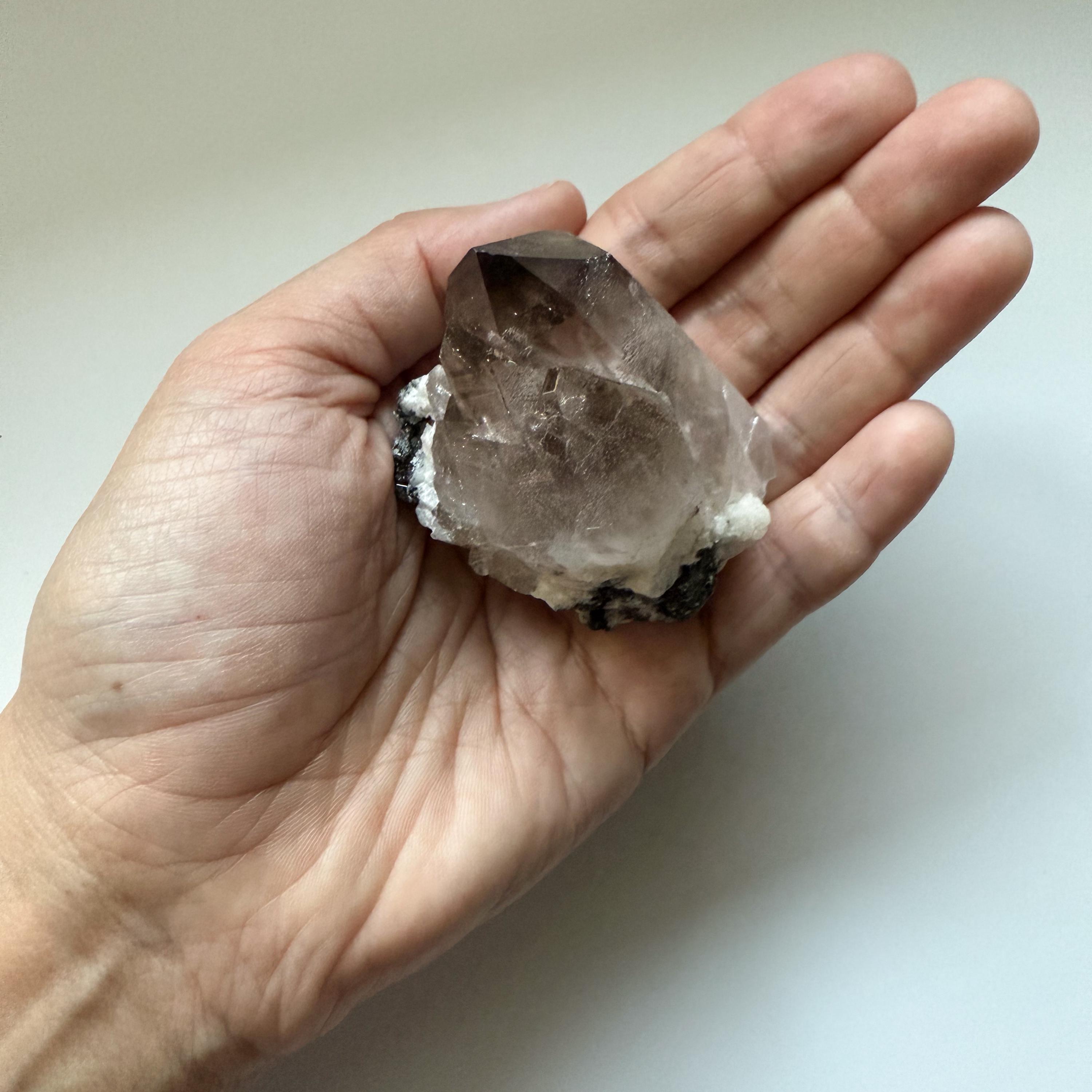 マラウイ産の輝くエゲリン入り自立型スモーキークォーツクラスター