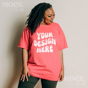May include: A woman wearing a bright pink t-shirt with the text "YOUR DESIGN HERE" in white. The shirt is a relaxed fit and has short sleeves.