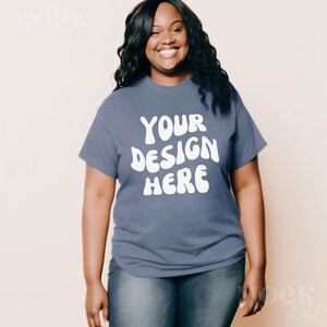 May include: A woman wearing a blue t-shirt with the text "YOUR DESIGN HERE" in white. The text is in a retro, wavy font.