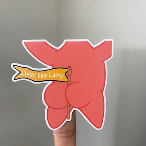 May include: A pink cartoon character holding a yellow flag with the text "Livin' like Larry".