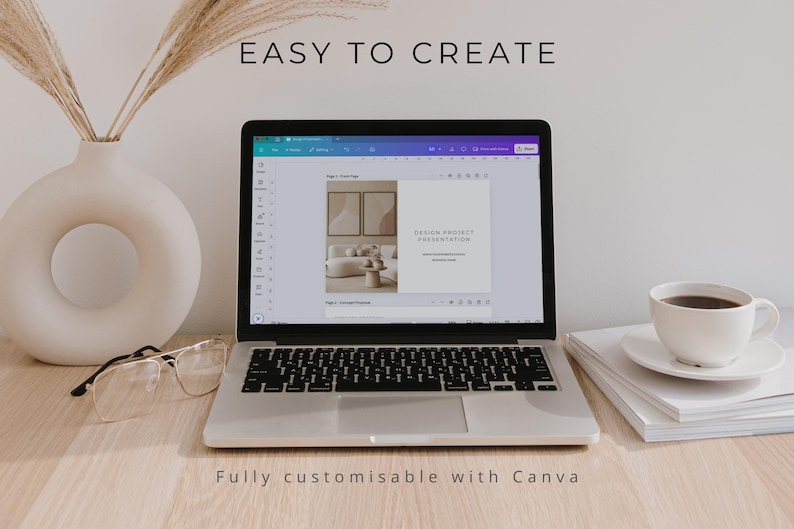 May include: A silver laptop displaying a design project presentation on its screen, with the text EASY TO CREATE above it. Beside the laptop are a white ceramic vase with dried grass, clear glasses, and a white coffee cup on a stack of books.
