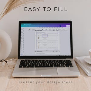 May include: A silver laptop displaying a digital document with the text EASY TO FILL and PRESENT your design ideas. The screen shows a table layout with icons and text. Beside the laptop are clear glasses, a white vase, and a coffee cup.