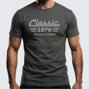 Puede incluir: Camiseta gris oscuro con el texto "Classic 1976 Limited Edition" en fuente gris claro. La camiseta tiene cuello redondo y mangas cortas. El texto está centrado en el pecho.