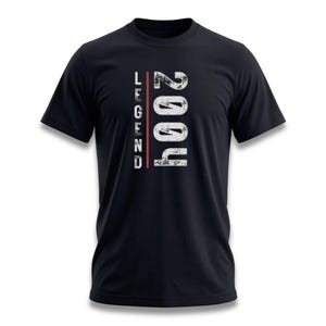 May include: Black t-shirt with the word "LEGEND" in white vertical text and the year "2004" in white, distressed font. A red vertical line runs through the center of the text. The shirt is a classic crew neck style.