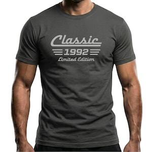May include: A charcoal gray short-sleeve t-shirt featuring the text Classic 1992 Limited Edition printed in a light gray color on the chest. The design includes horizontal lines above and below the year 1992.