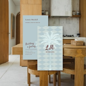 May include: Two business cards with a light blue background. One card has the text "Lonnie Mitchell, Founder & Creative Director" and "Building a feeling". The other card has a palm tree design and the text "L.M. INTERIORS".