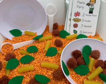 May include: A sensory bin with orange lentils, green felt leaves, brown pom-poms, yellow pasta, and a white bowl. A card with the text "Pasta Party" and a list of ingredients is visible in the background.