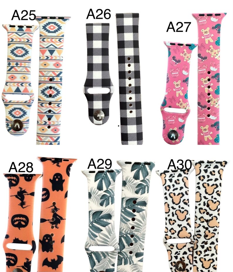 May include: A selection of patterned watch straps. Designs include geometric patterns, black and white gingham, teddy bears, Halloween characters, tropical leaves, and leopard print. Each strap has a metal clasp.