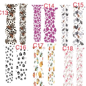 May include: A selection of watch straps featuring diverse patterns. Designs include butterflies, cow spots, chickens, paw prints, bees with honeycombs, and flamingos. The straps are in various colours, including white, purple, and pink.