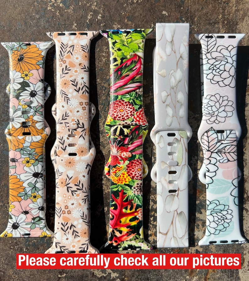 May include: Five different Apple Watch bands with floral and botanical prints. The bands are made of silicone and have a variety of colors and patterns. The bands are all in focus and are arranged in a row.
