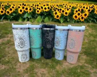May include: Five stainless steel tumblers with a sunflower design. The tumblers are in white, light blue, black, light blue, and pink.