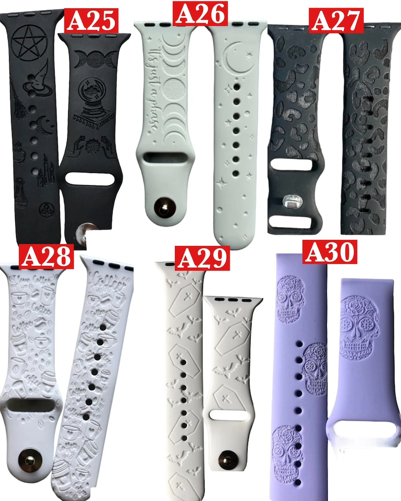 May include: A collection of watch bands in various colors and designs. Includes black bands with witchy symbols, a light green band with the text "It's just a phase", and a lavender band with sugar skull designs. Other bands feature coffee cups, coffins, and bats.