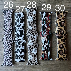 May include: Five different patterned Apple Watch bands. The bands are in a variety of colors and patterns, including leopard print, floral, and geometric. The bands are numbered 26 through 30.