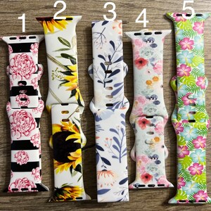May include: Five different Apple Watch bands with floral and tropical prints. The bands are numbered 1 through 5. The bands are all white with different colored floral and tropical prints.