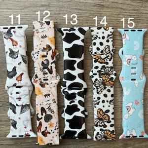 May include: Five different Apple Watch bands with various patterns. The bands are numbered 11 through 15. The patterns include chickens, dogs, cow print, butterflies, and llamas.