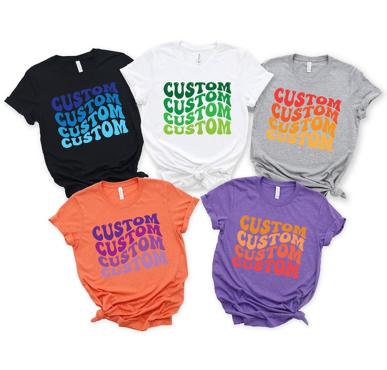 May include: Five t-shirts in different colors with the word "CUSTOM" repeated in a retro font style. The colors of the shirts are black, white, gray, orange, and purple.