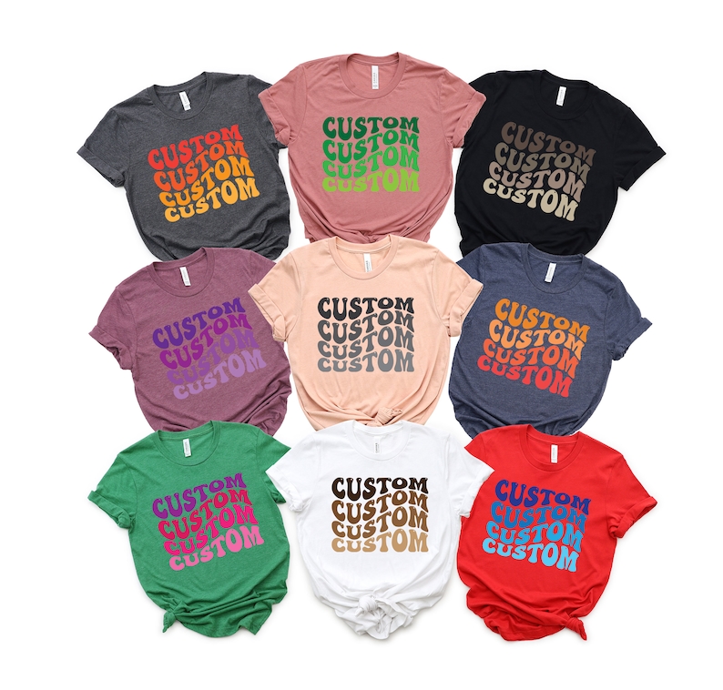 May include: Ten t-shirts in various colors with the word "CUSTOM" repeated in a retro font style. The shirts are arranged in a circle with the text facing outward.