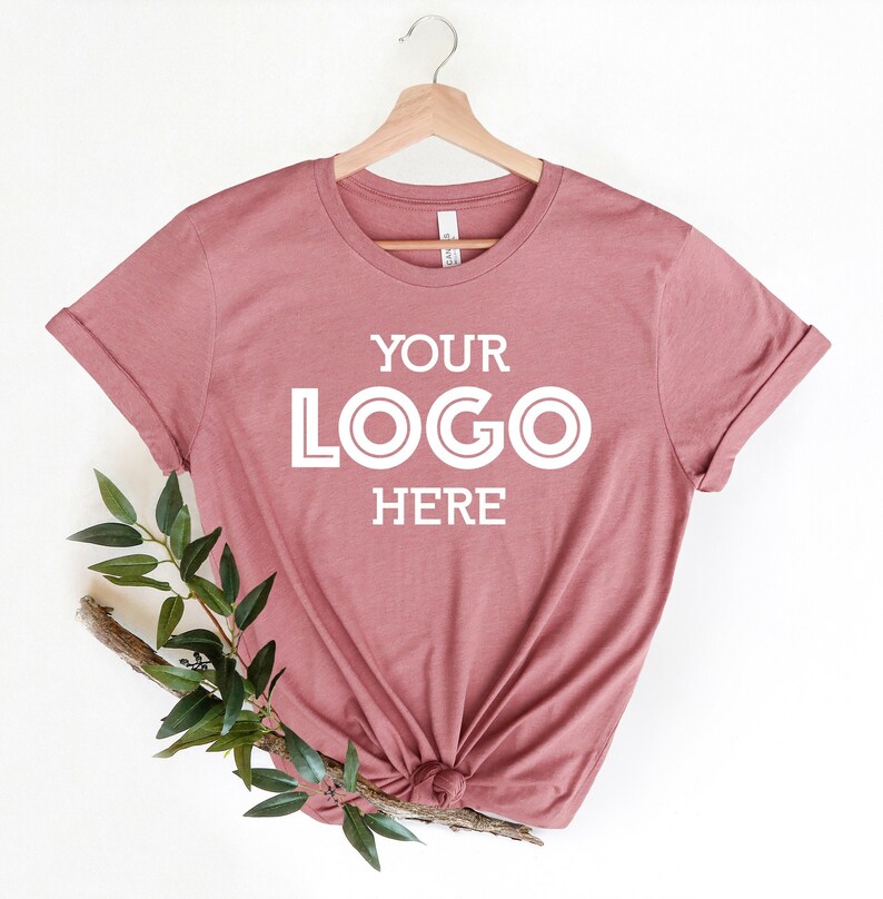May include: A dusty rose colored t-shirt with the text "YOUR LOGO HERE" in white.