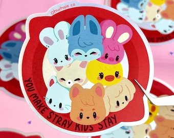 May include: A sticker featuring a group of cartoon animal characters in various colors, including blue, pink, yellow, and tan. The sticker has a red border with the text "YOU MAKE STRAY KIDS STAY" and the website "Ohwhale.co".