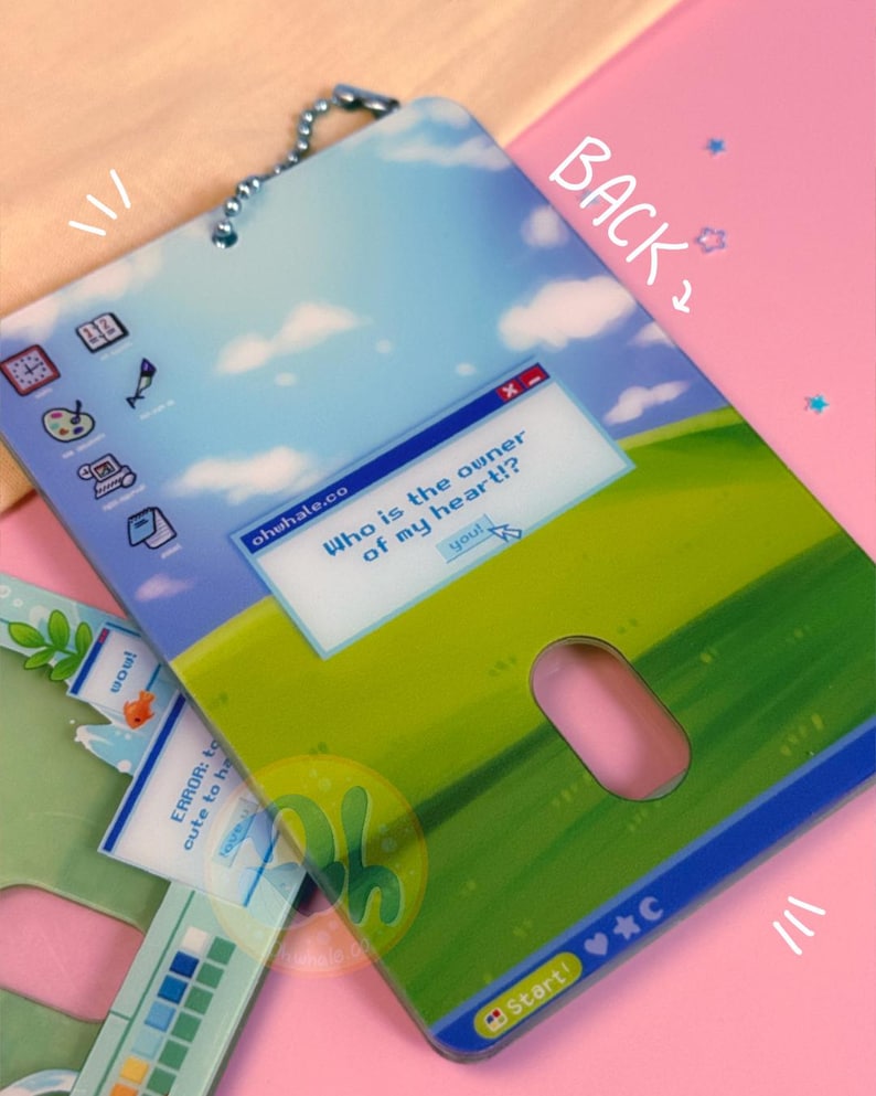 May include: A decorative tag with a whimsical computer-themed design. The tag features a blue sky and green field background with a pop-up window that reads "Who is the owner of my heart!?" and the word "you!" A pink mouse shape is cut out.