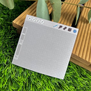 May include: A square sticky note featuring a light gray grid pattern and a digital interface design. The top toolbar displays icons for tools like a wrench, brush, and eraser, while the left side includes a vertical slider and an undo arrow icon.
