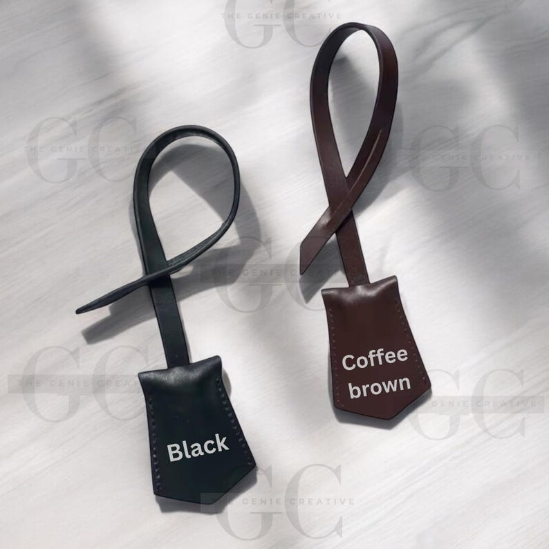 May include: Two leather keychains with a pointed tag. The keychain on the left is black with the word "Black" printed on the tag. The keychain on the right is brown with the words "Coffee brown" printed on the tag.