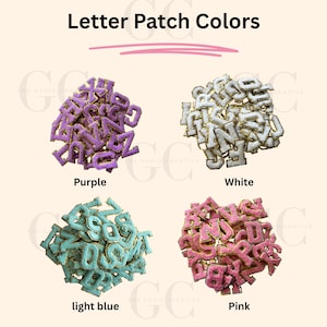 May include: Assortment of fuzzy letter patches in four colors: purple, white, light blue, and pink. Each letter patch has a gold outline.