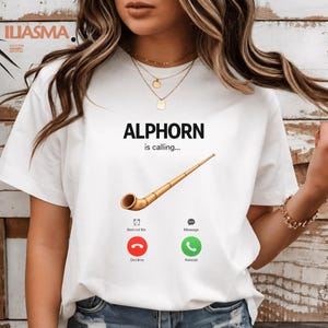 May include: White t-shirt with the text "ALPHORN is calling..." and an illustration of an alphorn. Below the text are two phone icons with the words "Decline" and "Accept".
