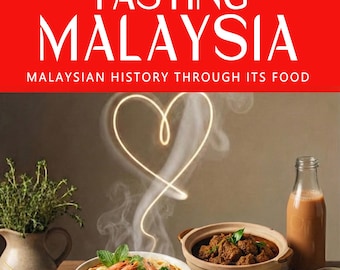 Op de afbeelding: Boekomslag met de titel "TASTING MALAYSIA" in witte letters op een rode achtergrond. De afbeelding toont verschillende Maleisische gerechten, waaronder noedels met garnalen, satay en rijst met bijgerechten. Een hartvormig lichtontwerp staat op de achtergrond.