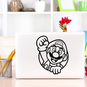 K&ouml;nnte beinhalten: Ein schwarz-wei&szlig;er Aufkleber von Mario, einer Videospielfigur, auf einem wei&szlig;en Laptop. Mario tr&auml;gt einen Hut und einen Schnurrbart. Er h&auml;lt seine Faust in die Luft.