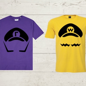 May include: Two t-shirts with a black graphic of a video game character's hat and mustache. The shirt on the left is purple and the shirt on the right is yellow.