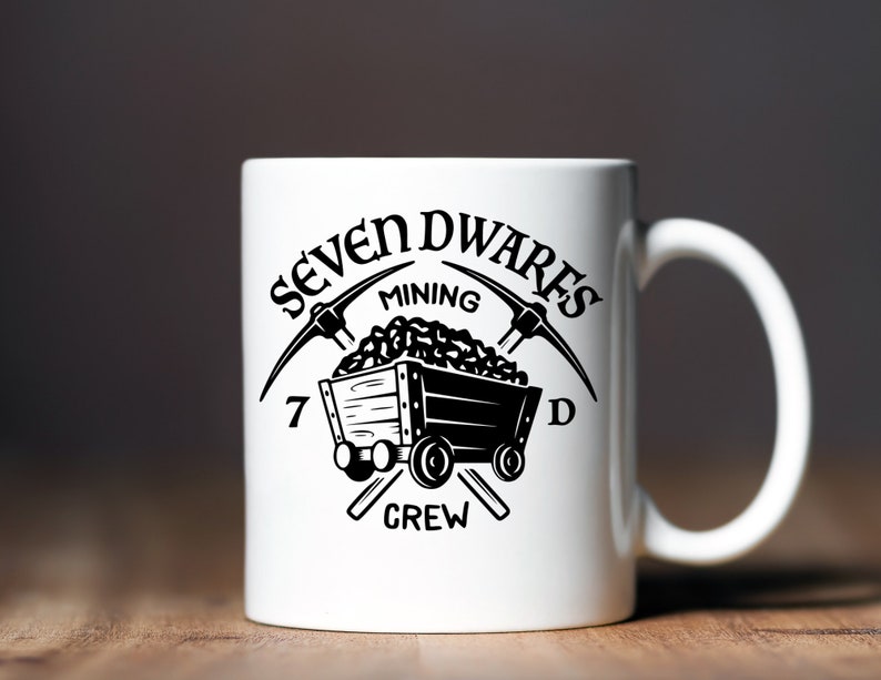 May include: White ceramic mug with a black graphic of a mining cart filled with coal and two crossed pickaxes. The text "Seven Dwarfs Mining Crew" surrounds the graphic.