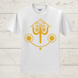 May include: White t-shirt with a gold graphic of a stylized house with a smiling face and two sun-like designs on either side.