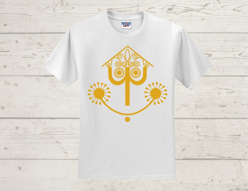 May include: White t-shirt with a gold graphic of a stylized house with a smiling face and two sun-like designs on either side.