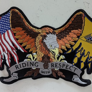 May include: A black embroidered patch with an eagle holding an American flag and a yellow patch with the text "PATRIOT GUARD RIDERS". The eagle is holding a banner with the text "RIDING WITH RESPECT".