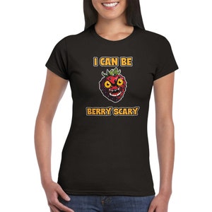 May include: Black t-shirt with a graphic of a red strawberry with a scary face and the text "I can be berry scary" in orange.