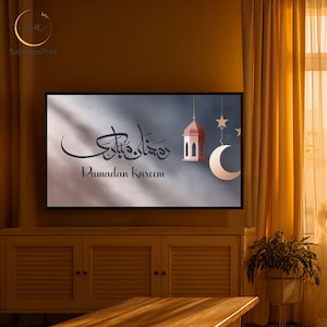 Pu&ograve; includere: Stampa incorniciata con la scritta "Ramadan Kareem" in calligrafia. L'opera d'arte include una lanterna rossa, una luna crescente e stelle su uno sfondo sfumato grigio e blu. La stampa &egrave; esposta su un mobile in legno.