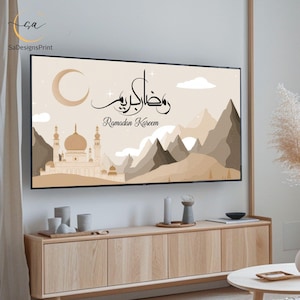 Pu&ograve; includere: Stampa artistica incorniciata con sfondo beige, raffigurante una moschea, montagne e una luna crescente. Il testo "Ramadan Kareem" &egrave; scritto in arabo e inglese.