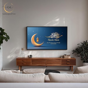 Pu&ograve; includere: Stampa artistica digitale incorniciata con una luna crescente e una lanterna su sfondo blu. L'opera d'arte include la calligrafia araba e le parole "Ramadan Kareem". La stampa &egrave; esposta sopra un mobile in legno.