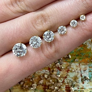 May include: Five pairs of round, clear, cubic zirconia stud earrings in different sizes, set in gold.