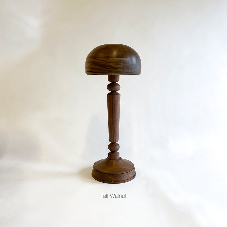 Op de afbeelding: Een hoge, houten hoedvorm met een ronde, walnootkleurige bovenkant en een slanke, geflute basis. De basis heeft een ronde, vlakke bodem. De tekst "Tall Walnut" is onder de hoedvorm afgedrukt.