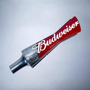 May include: A red and silver Budweiser beer tap handle. The handle features the Budweiser logo in white script on a red background. The tap is silver with an ornate design.