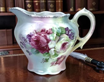 Cremeira antiga de porcelana alemã com estampa floral de rosas e violetas, borda ondulada, estilo vitoriano.